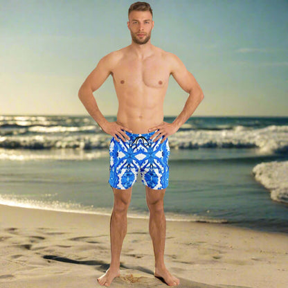 Model wearing Ocean Blue Cymatic Men’s Swim Shorts on the beach, showcasing stylish and quick-dry swimwear.