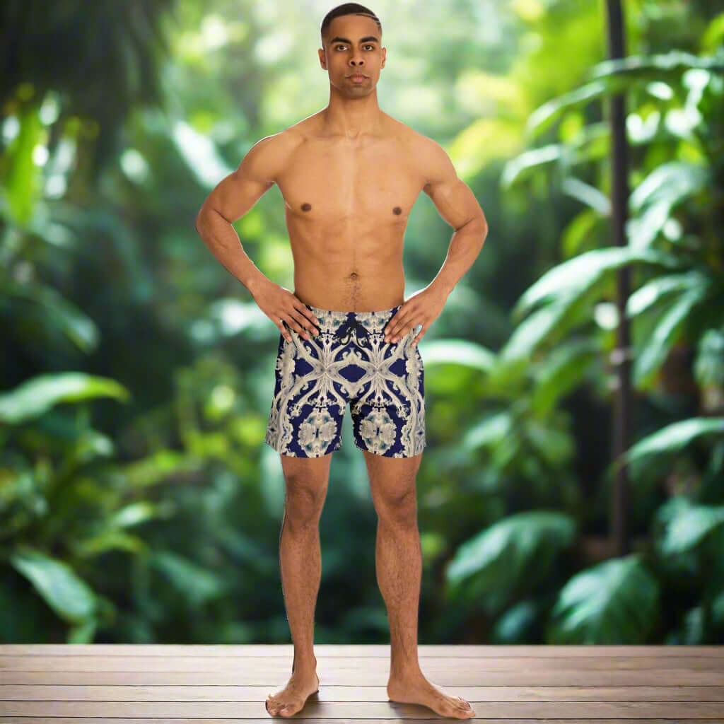 Model wearing Clear Smoke Cymatic men's swim trunks in a tropical setting, showcasing stylish above-the-knee design.